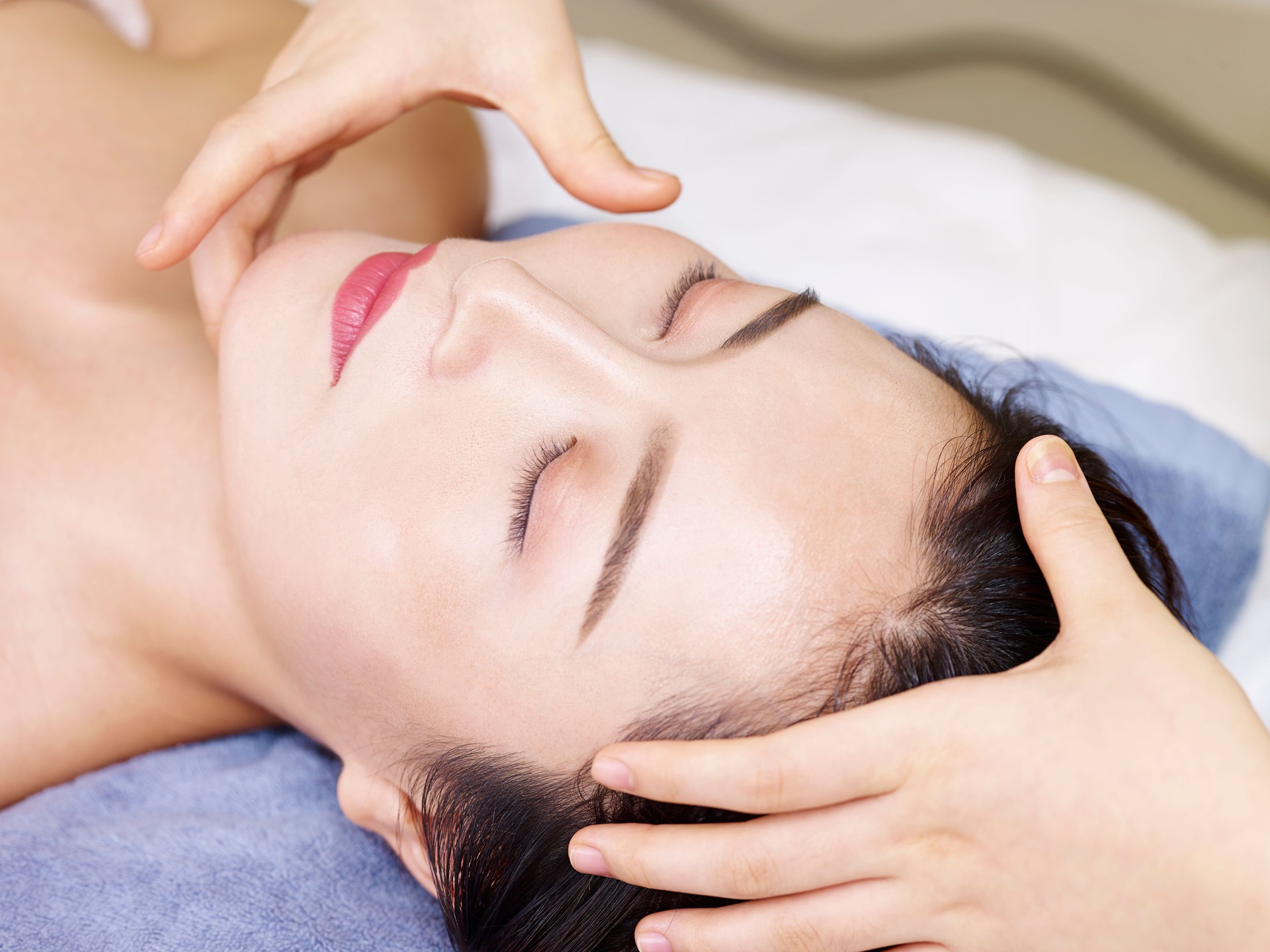 young asian woman enjoying a face massage